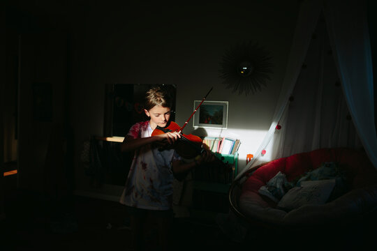 Girl plays violin in bedroom