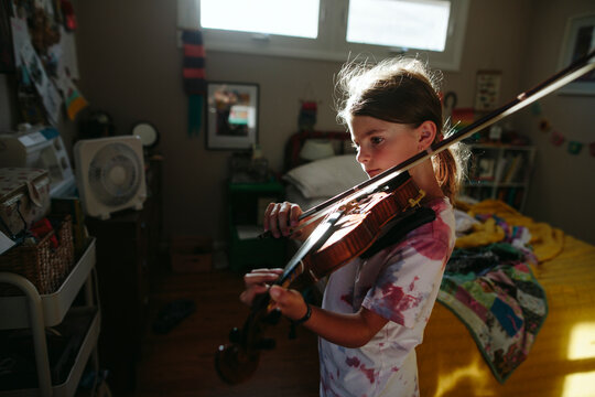 Girl plays violin in bedroom