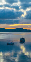 Aerial sunrise waterscape with boats, rain clouds and reflections