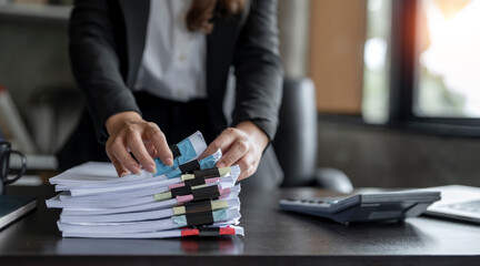 Fototapeta Businesswoman hands working in Stacks of paper files for searching and checking unfinished document achieves on folders papers obraz