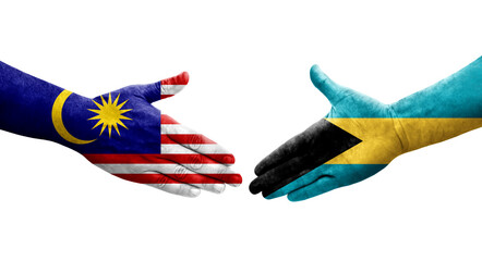 Handshake between Bahamas and Malaysia flags painted on hands, isolated transparent image.