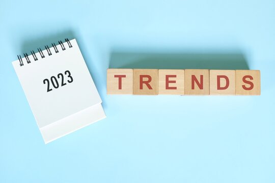New year 2023 new trends concept. Desk calendar flat lay in blue background.