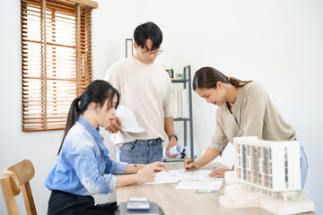 Engineering construction concept, Engineers team point blueprint of building to discussing together