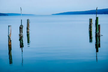 A placid Lake seneca early in the morning as the fog rolls across the water