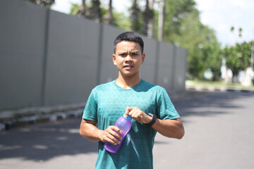 Young asian boy exercising and drinking water in a bottle