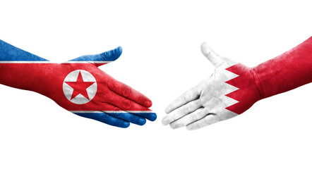 Obraz premium Handshake between Bahrain and North Korea flags painted on hands, isolated transparent image.