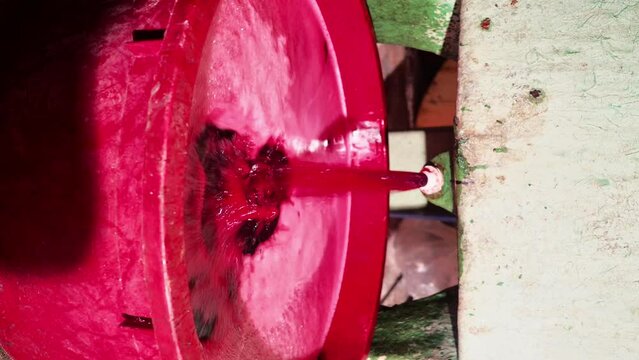 new red wine flowing from tank from recent grape harvest - filtering and storing