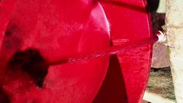 new red wine flowing from tank from recent grape harvest - filtering and storing
