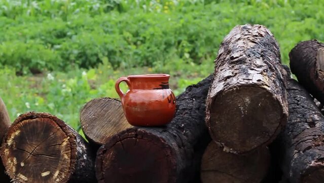 slow motion slider of traditional cup of mexican coffee on wooden logs in field