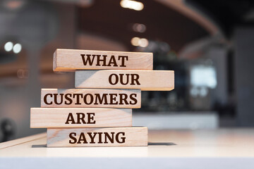 Wooden blocks with words 'What Our Customers are Saying'.
