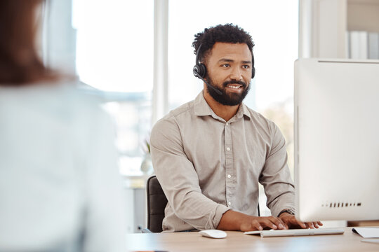 Call center, customer service and telemarketing with a man consultant working on a computer in the office. Crm, contact us and sales with a male support agent at work or consulting on a headset