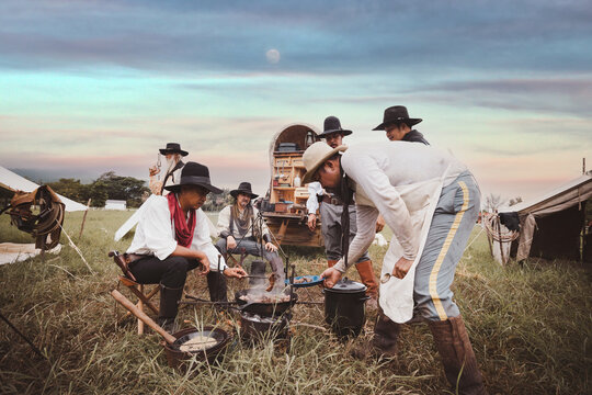 Cowboys group have outdoor campfire ,boiling hot water and coffee in morning travel avenger western life style 1080s concept.