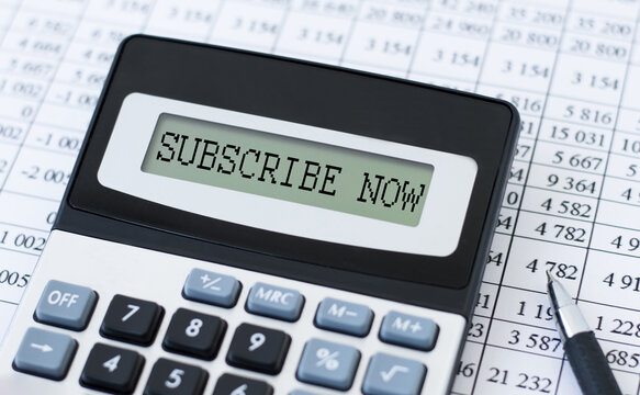 SUBSCRIBE NOW inscription on the screen of the calculator on the table with documents