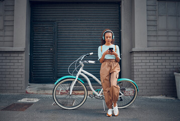 Headphone, woman and phone with bicycle in city listening to music or podcast streaming outdoor in...