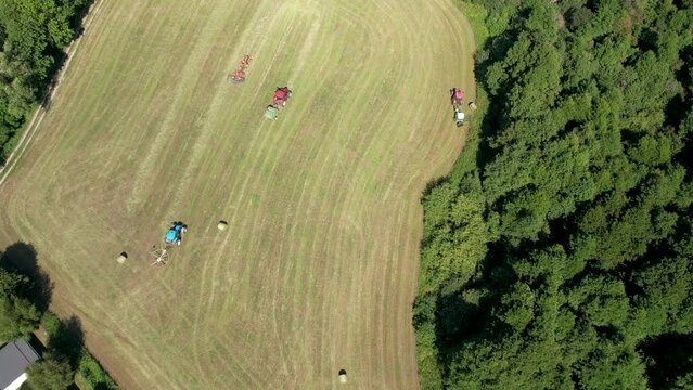 Bird's Eye View Over Tractors Working On Agricultural Field In Chmielno, Poland - aerial drone shot