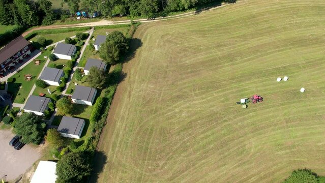 Hay Bale Tractor Working On The Field In Chmielno, Poland - aerial top down