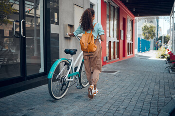 Bike, city and back view of black woman, walking on street or urban road outdoors. Exercise,...