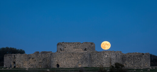 October Hunters full moon rise behind the ruins of Camber Castle near Rye east Sussex south east England