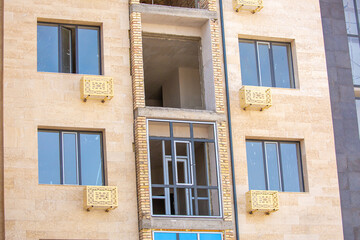The construction team is working on the construction of the house. Artisans do their work in the open air. Scaffolding at the facade of the building.