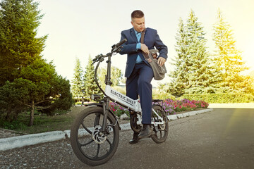 A new modern alternative mode of transport. Eco-friendly electric bike. businessman commuter with...