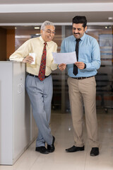 Fototapeta na wymiar Indian businesspeople discussing paperwork in a modern office