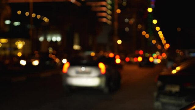 Unfocused city lights at night. Abstraction. City car traffic. Blurred backgrounds. Slow motion