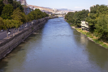 Fototapeta na wymiar View of the Kura River from the bridge. Georgia. Tbilisi. Urban landscape.
