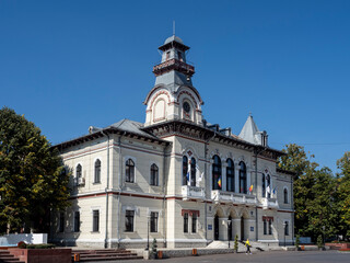 Fototapeta na wymiar Gorj Prefecture building in Targu-Jiu. Next to is the monument of Ecaterina Teodoroiu, heroine from Romania.