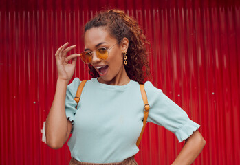 Trendy, fashion of black woman cool sunglasses with a playful attitude on red background outside....