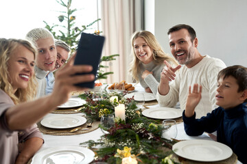 Caucasian family of different generation taking selfie over Christmas table
