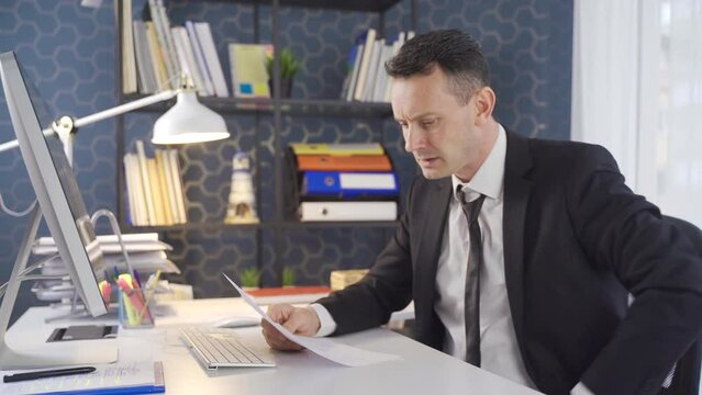 Getting bad news. Businessman reading paperwork.
Businessman looking at things that are not going well is bored and sad.
