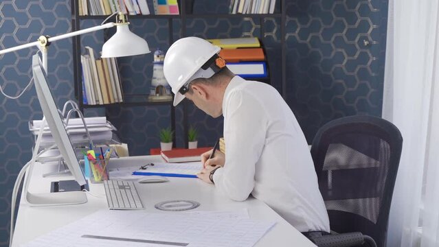 The engineer draws the project. Drawing projects and drawings with a ruler.
Engineer working at his desk in the office working on the project.
