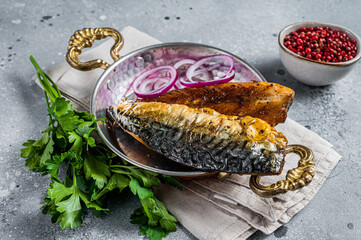 Roasted mackerel soba fish fillet with herbs in a skillet. Gray background. Top view
