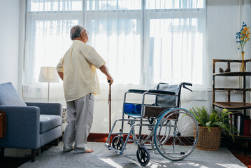 Asian senior old man with wheelchair walking with walker cane stick in nursing home, elderly mature disabled man patient, elderly health care concept. - obrazy, fototapety, plakaty