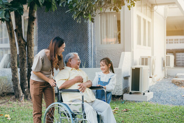 Disabled senior grandpa on wheelchair with grandchild and mother in park, Happy Asian multi generation family having fun together outdoors backyard, Grandpa elderly and little child smiling and laugh. - obrazy, fototapety, plakaty