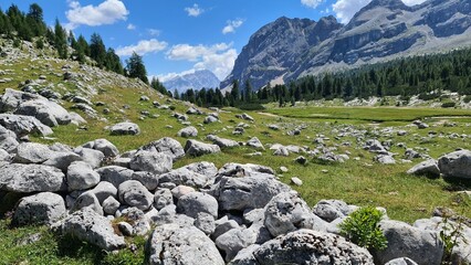 Fototapeta na wymiar Val Badia, Italy-July 18, 2022: The italian Dolomites behind the small village of Corvara in summer days with beaitiful blue sky in the background. Green nature in the middle of the rocks.