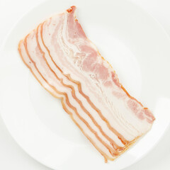 Thin slices of bacon on a plate, smoked pork.