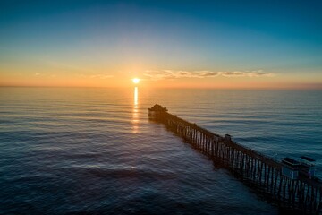Aerial view of dock in sea during sunset
