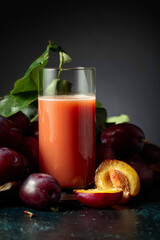 Plum juice and fresh purple plums.