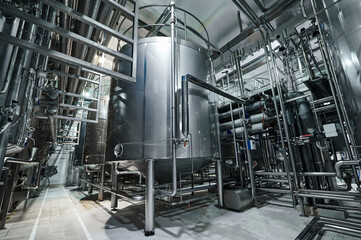 Stainless steel tanks, many pipes and valves, food production.
