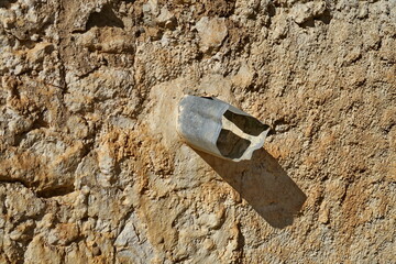 Gouttière artisanale dans un mur de pierre.