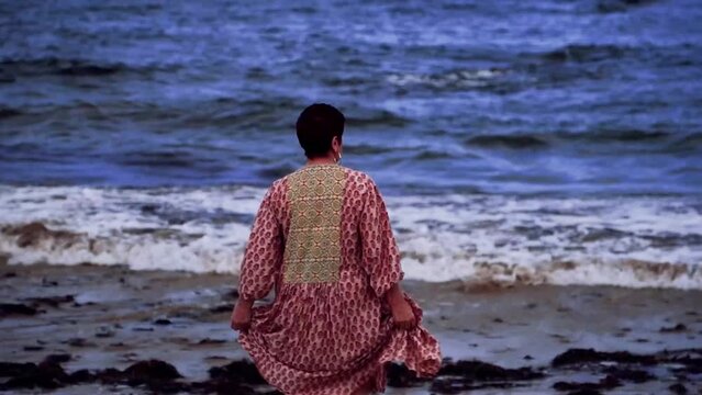 Woman walking near the sea, Comillas, Cantabria, Spain