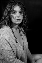 Junge Frau im Cardigan blickt sch&uuml;chtern in die Kamera