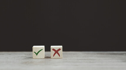 Tick mark and cross mark x on wooden cubes. Wooden blocks with green check mark and red x. Concept...