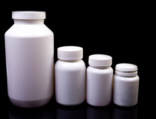 Medical pills in white jar on an isolated black background with reflection