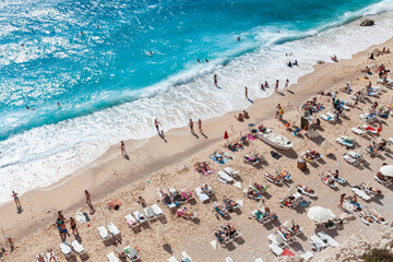 Fototapeta na wymiar people by the sea sunbeds and umbrellas in a turquoise bay, Antalya Kaputaş Beach