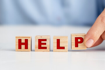 Businesswoman holding wooden block, HELP concept.