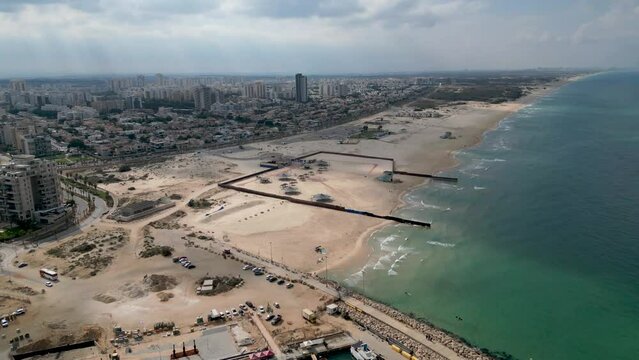 Aerial 4k scenic video of Ashdod beach front almost completely vacant during an overcast cloudy day