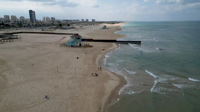Aerial 4k scenic video of Ashdod beach front almost completely vacant during an overcast cloudy day