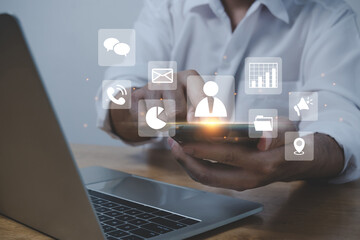 Contact Us. businessman hand touching on mobile smart phone and computer with virtual social media icon diagram, business finance, internet data technology, digital marketing, social network concept